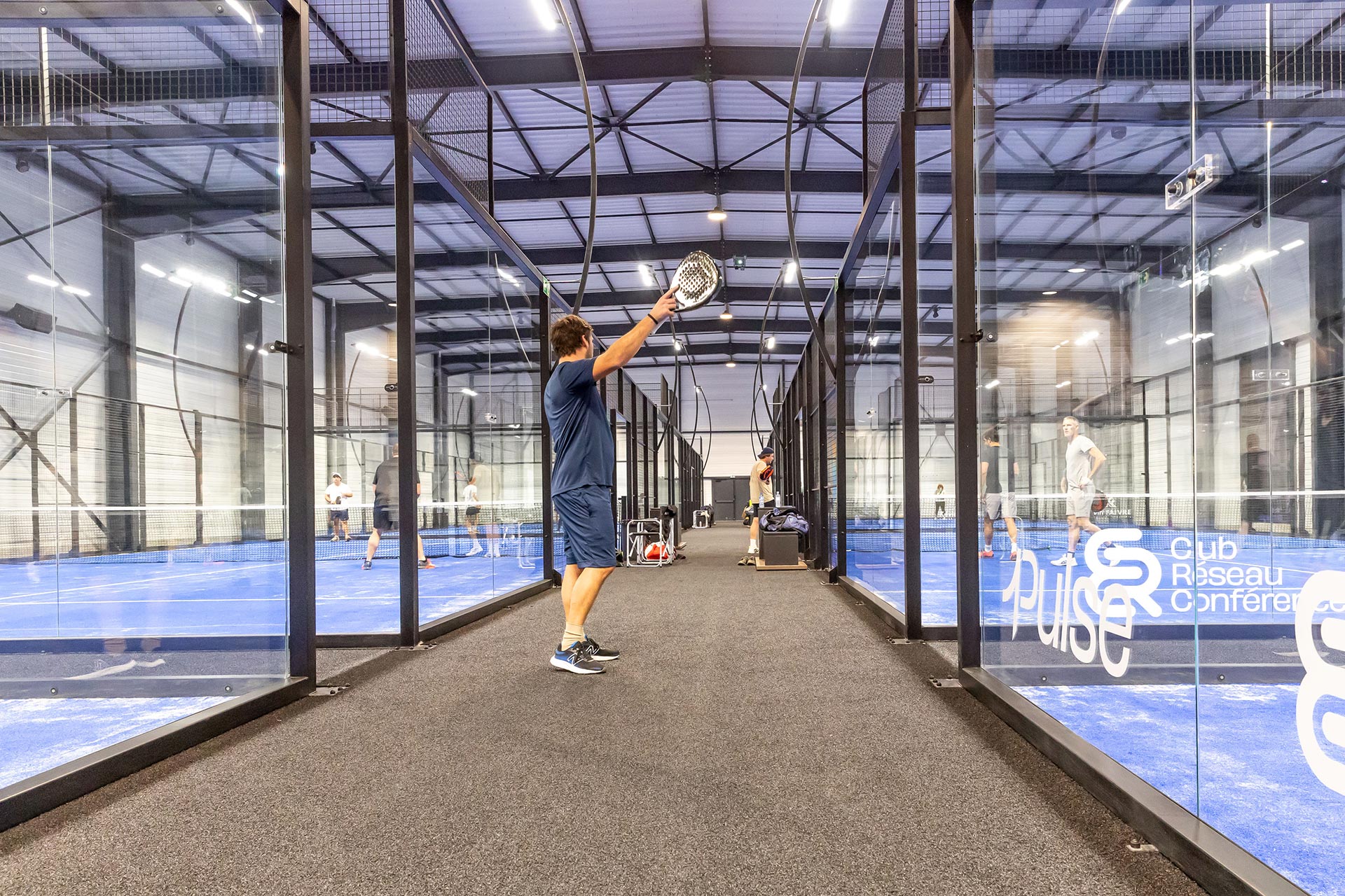 Terrain de padel indoor avec parois vitrées panoramiques au Beaune Padel Club