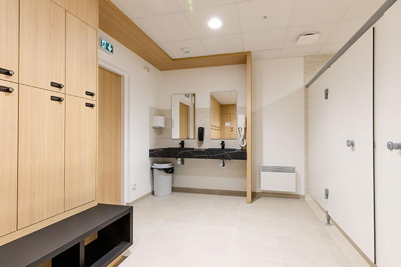 Vestiaires et sanitaires modernes avec douches et équipements haut de gamme